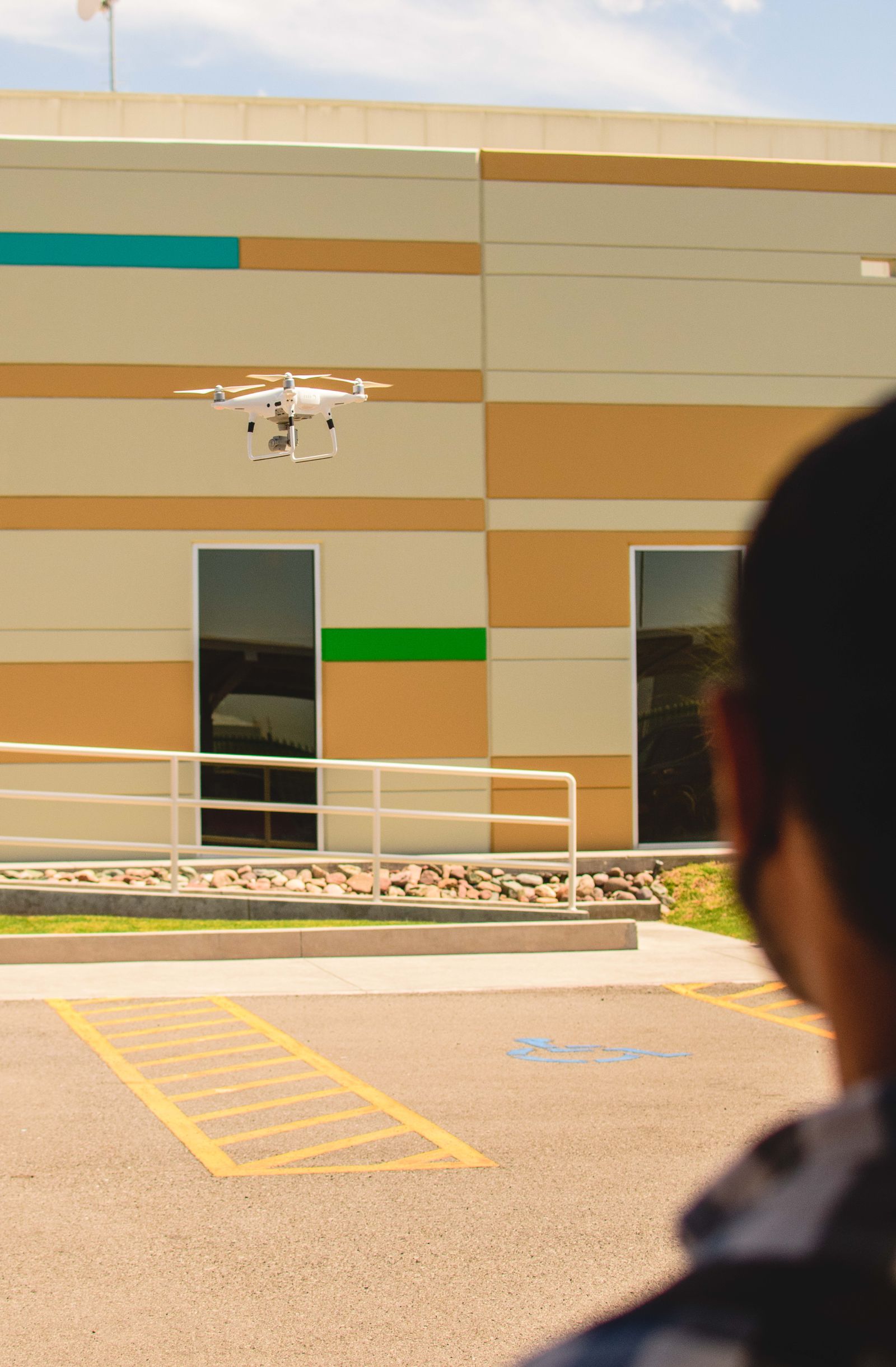 Drone flying beside a modern commercial building during an exterior review
